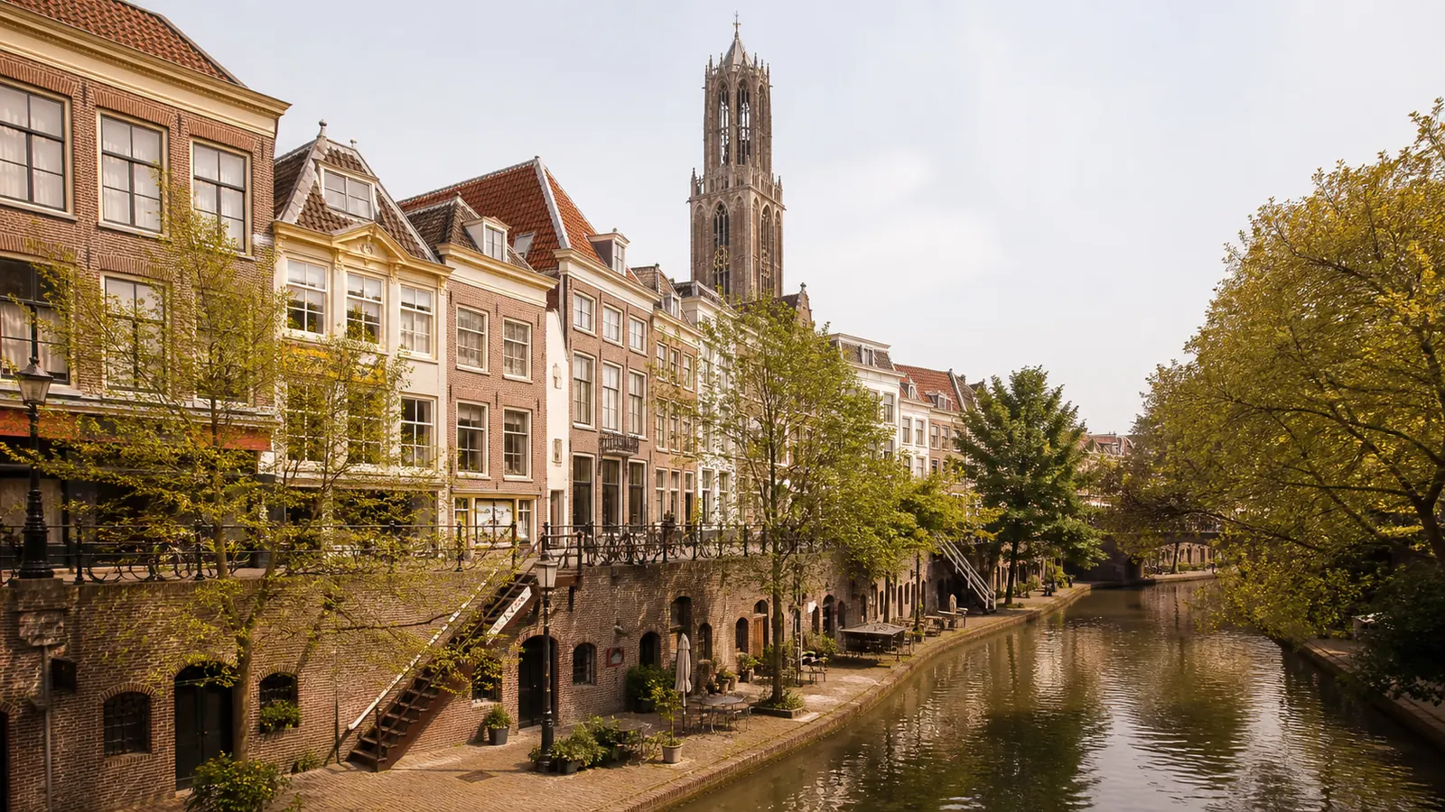 herkenbaar stadsbeeld van utrecht: werven en de Domtoren langs de Oudegracht, warm middaglicht; warme editorial-stijl, geen close-ups van personen